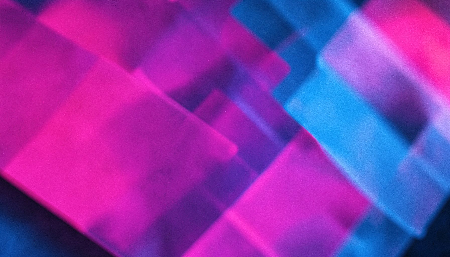 Close-up abstract composition of overlapping translucent shapes in pink and blue, suggesting pixel-level precision
